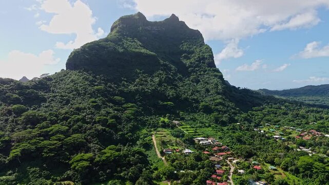 Bora Bora Island, French Polynesia. Drone Shot of Mount Otemanu and Hillside Village Homes on Sunny Day