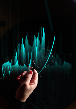 A woman's hand points to neon binary charts and growth graphs