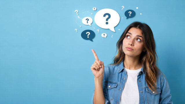 Young woman points upward while looking thoughtful with question mark speech bubbles on a blue background