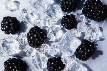 Fresh ripe blackberries and clear ice cubes in rippling water © Юрий Ваховский