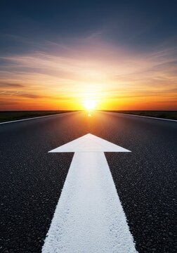 A low angle perspective shows a painted white arrow on a dark asphalt road pointing toward the bright horizon, symbolizing a clear path, future, perspective, asphalt