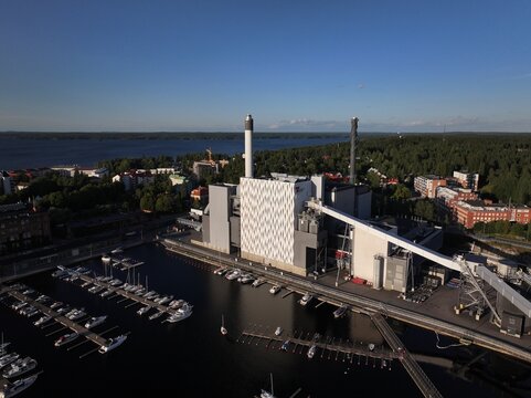 Aerial view of the Naistenlahti power plant situated by the marina with numerous boats on the lake in Tampere, Pirkanmaa, Finland.