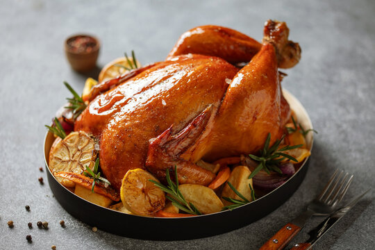 Fried chicken and vegetables on a black plate. Thanksgiving Day. Christmas dinner. Gray background.