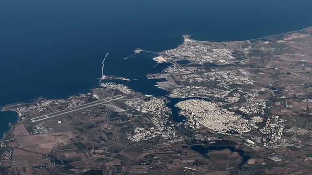 flying along Brindisi, a city in the region of Apulia in southern Italy, with Brindisi Papola Casale Airport, Cityscape and Brindisi Harbor, located at Adriatic Sea coastline - 4k aerial footage