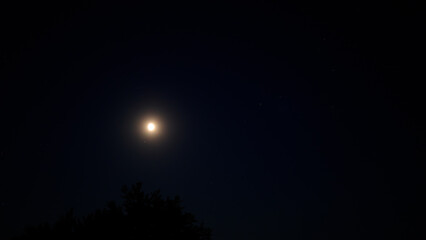 Moon on a night sky with landscape mountain silhouettes. © astrosystem