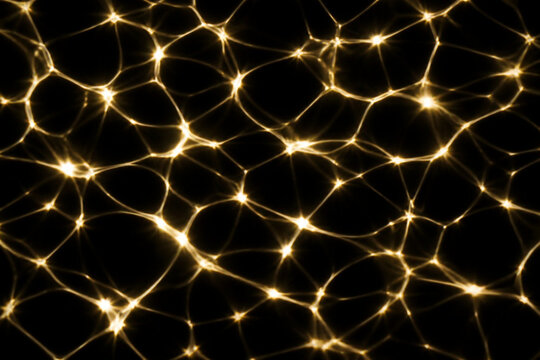 Abstract golden light caustic pattern on black background, shimmering water surface reflection, glowing network texture, luxury background