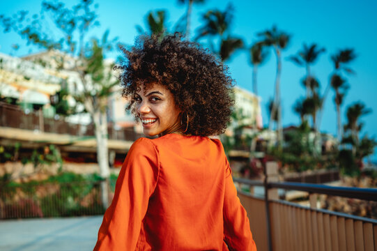 Young woman radiates the love of summer, travel, joyfully celebrating a fun holiday with arms raised