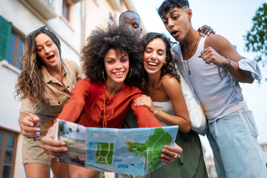 Friends enjoy a summer afternoon exploring the city, laughing over a map and discovering the city