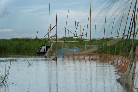 Traditional Fishing Net Structure on a Calm River in Bangladesh