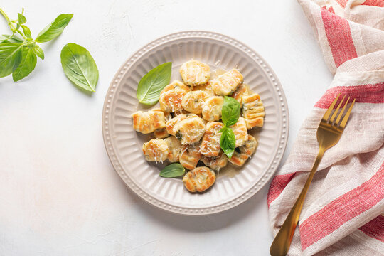 Homemade Potato Gnocchi with Basil leaves and parmesan Cheese in plate on the table