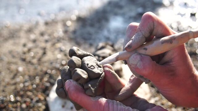 Clay sculpting hands, creating art on a sunny beach, outdoor creative craft, artistic expression