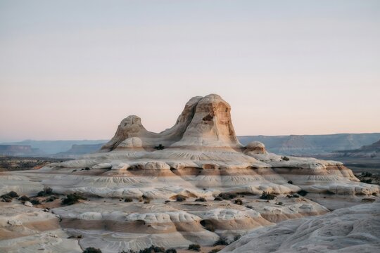 The unique white sandstone rock formations of the desert landscape under a soft evening sky with natural erosion patterns and textures