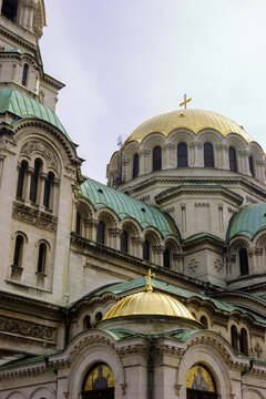 The Alexander Nevsky Cathedral in Sofia, Bulgaria, with its iconic golden domes and green roofs under a cloudy sky.