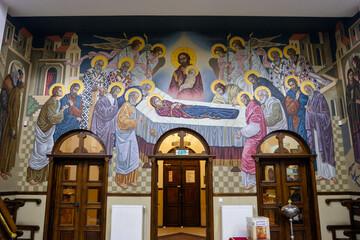 The Dormition of the Theotokos, a mural depicting the Virgin Mary surrounded by Jesus, angels, and apostles in a church. © Nick