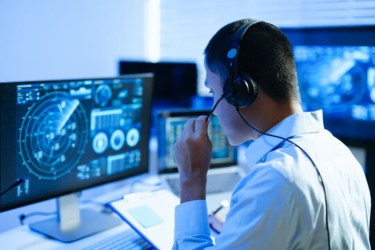 Professional man monitoring flight data and aircraft tracking on digital radar screens, combining aviation technology, data analysis and modern computer systems.