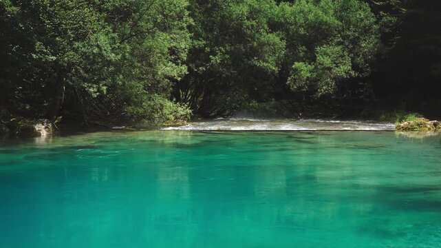 View of the striking turquoise water of Oko Skakavice, known as The Eye, a crystal-clear karst spring surrounded by pristine nature near Gusinje, Montenegro.