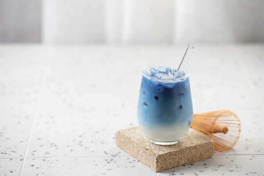 Refreshing cold iced blue matcha tea latte in a tall glass, perfect for a summer day. Copy space