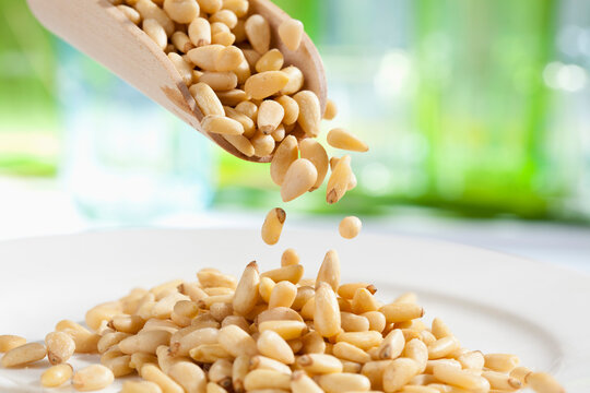 Soya beans pouring from wooden scoop, close up