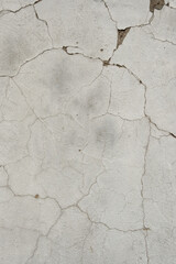 Fototapeta premium Old white cracked plaster wall texture background with peeling clay stucco surface, weathered rustic whitewashed building wall backdrop for industrial graphic design wallpaper project.