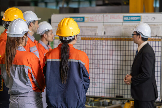 Professional senior lead supervisor engineer man training and planning project schedule time table with engineer team in industry factory