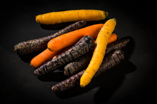 Various sorts of carrots on dark ground
