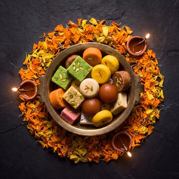 Diwali 2026 traditional indian sweets with diya lamps, flat lay