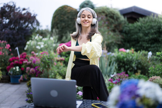 Woman stretches in the garden during a home office break