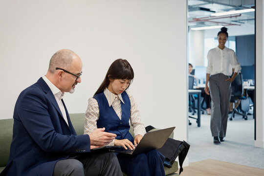 Colleagues review an interview on a laptop in a London office
