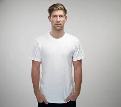 Portrait of young man with hands in his pockets wearing white t-shirt