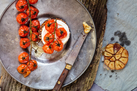 Roasted tomatoes, crostini with goat cheese, garlic on plate