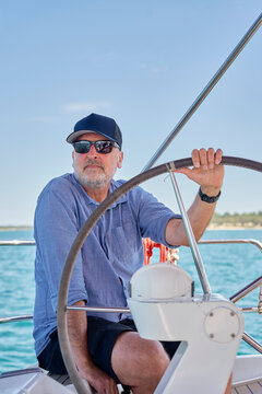 A man steers a sailboat on the ocean in Croatia