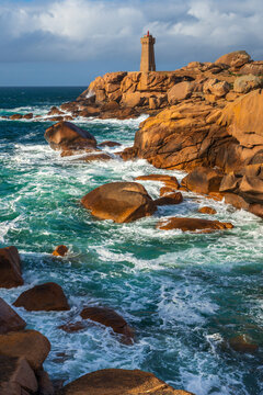 Phare de Mean Ruz lighthouse stands on the rocky coast of Brittany