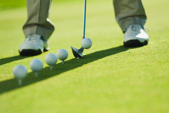 Golfer practices a putt on the green in Kastelruth Italy