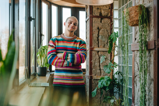 Confident young businessman stands in a modern green office