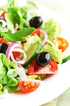 Salad with Olives, Tomatoes and Cucumber on wooden Background. Healthy Snack Idea. Close up