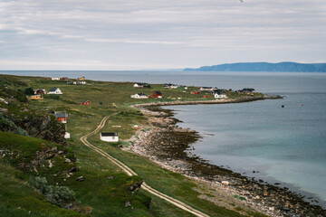 Panoramic view of remote houses dotted along the arctic coastline of Magerøya island on the route to North Cape, Finnmark, Norway. © Michele