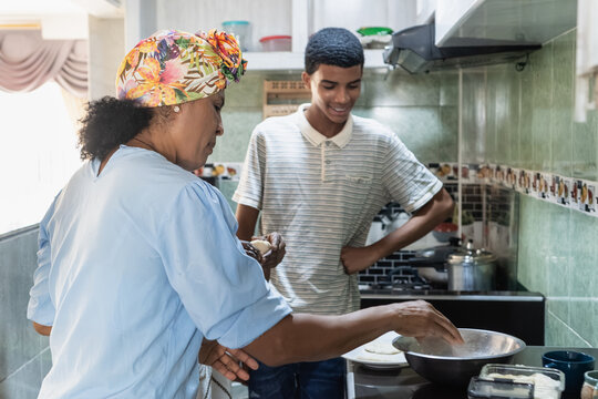 Grandmother and grandson cooking together in kitchen