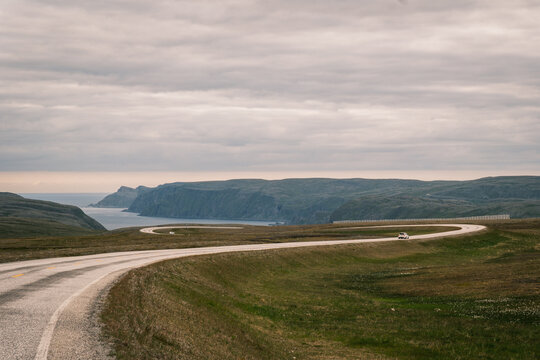 Curving asphalt road E69 sweeping along high ocean cliffs towards the North Cape plateau on Mager&oslash;ya island, Finnmark county, Norway
