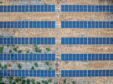 Aerial view of the Ellensburg solar farm featuring rows of photovoltaic panels set against dry grass and patches of green vegetation in Ellensburg, Washington, United States.