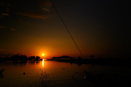 Golden Sunset Over Calm Tropical Water with Island Silhouettes