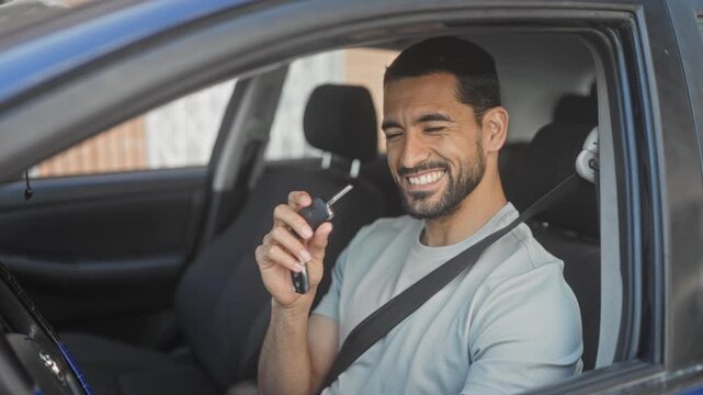 Man in car wearing seatbelt holding car key and waving hand while smiling and driving in street; friendly greeting.