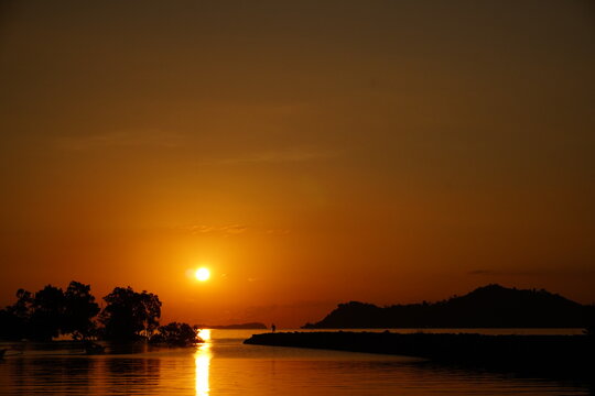 Vibrant Orange Sunset Over Tropical Sea and Silhouetted Islands