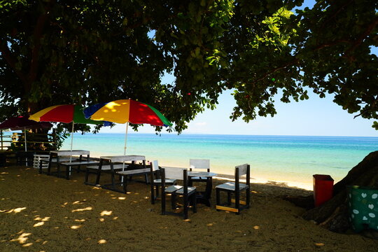 Colorful Beach Umbrellas and Wooden Seating Overlooking Turquoise Sea