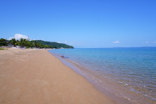 Wide Sandy Tropical Beach with Clear Blue Sea and Palm Trees
