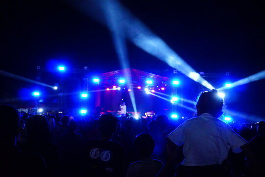 Outdoor Night Concert with Bright Blue Stage Lights and Crowd