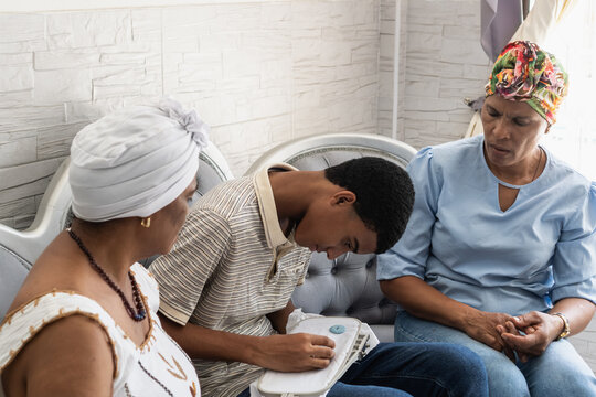 Multigenerational family teaching grandson sewing craft at home