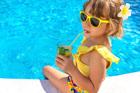 Child with juice in the pool. Selective focus.