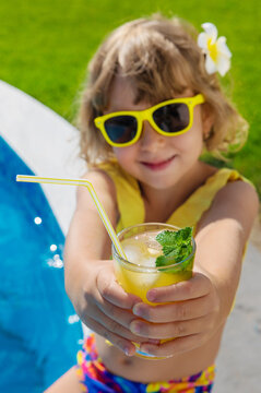 Child with juice in the pool. Selective focus.