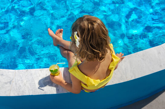 Child with juice in the pool. Selective focus.