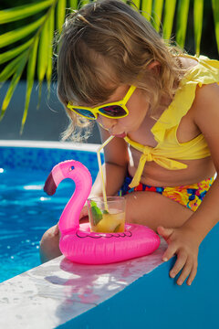 Child with juice in the pool. Selective focus.